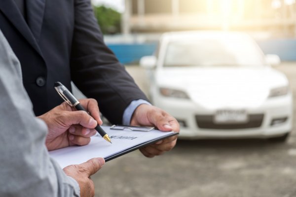 Extended Auto Warranty contract in front of car